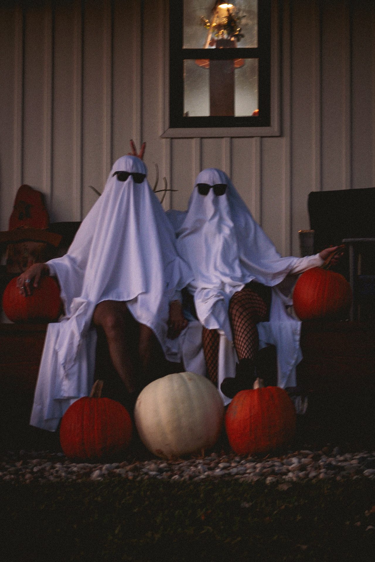 Ghostly figures on a porch among pumpkins at dusk. Photograph by Isaiah Sanchez.