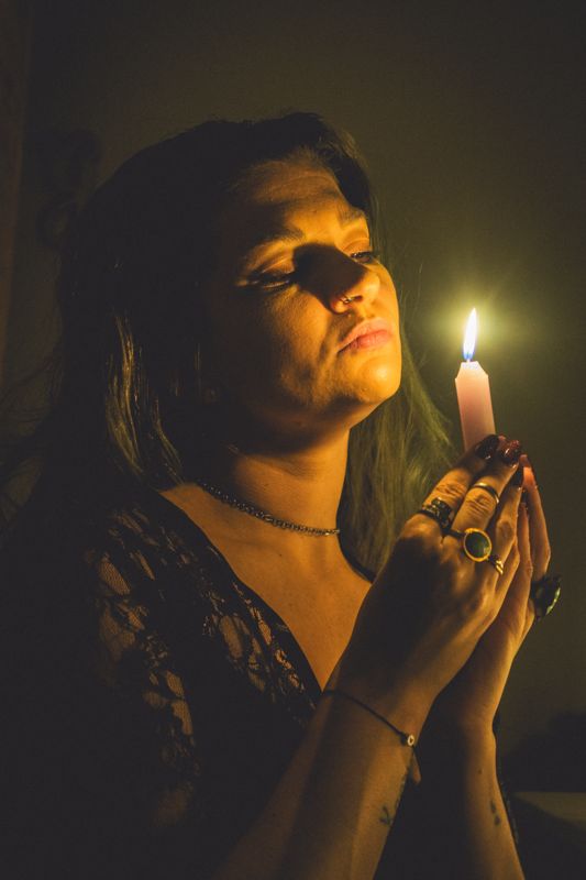 Lifting the flame — from By Candlelight. Photograph by Isaiah Sanchez.