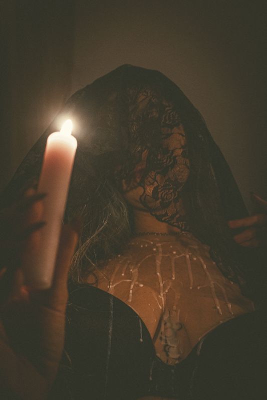 Veiled, leaning in — from By Candlelight. Photograph by Isaiah Sanchez.
